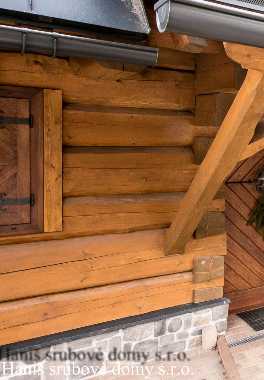Detail rohového spoje srubové stěny se zavřenou dřevěnou okenicí