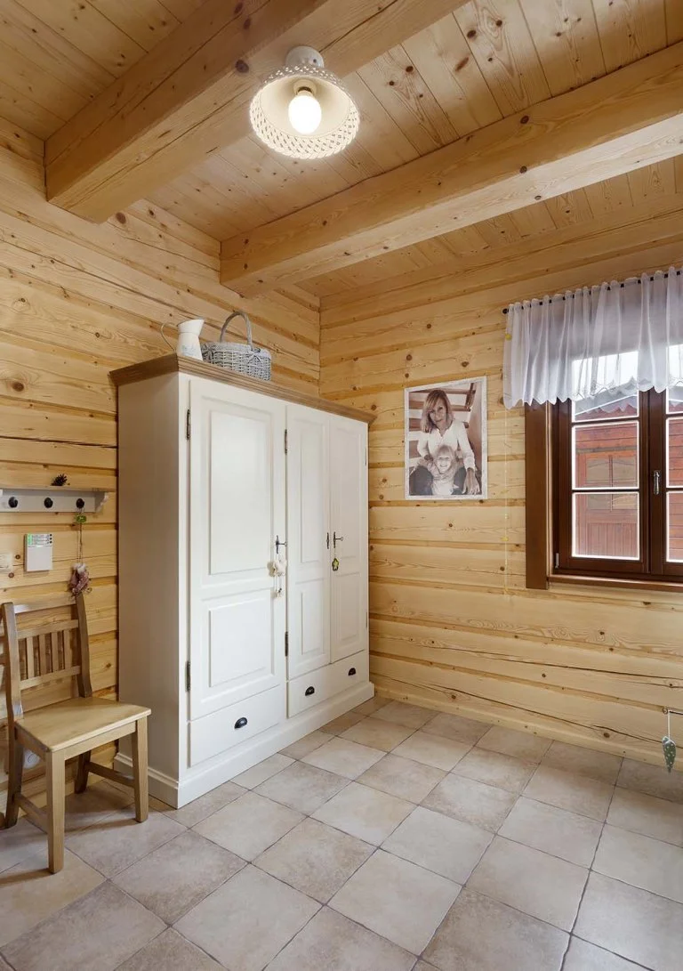 Šatní skříň a rodinná fotografie ve dřevem obložené místnosti