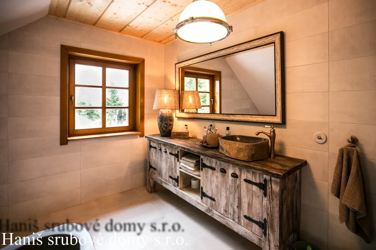 Koupelna s kamenným umyvadlem a starobylou dřevěnou skříňkou